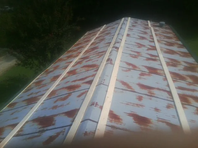 Rusted metal roof panels with new wood purlins before replacement — Storm Damage Roof Repair in Queens Village by Roofing Brothers